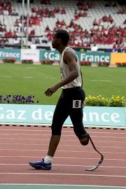 Atleta paraolímpico de atletismo usando uma prótese de corrida.